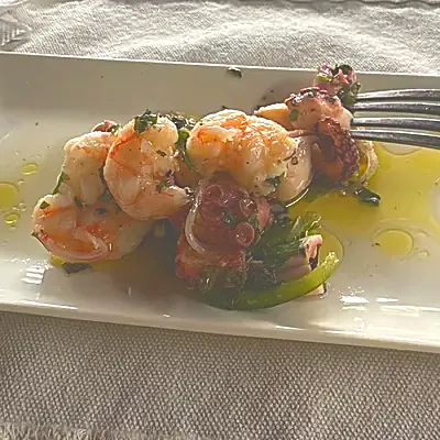 Camarones y pulpo con aceite de oliva y perejil.