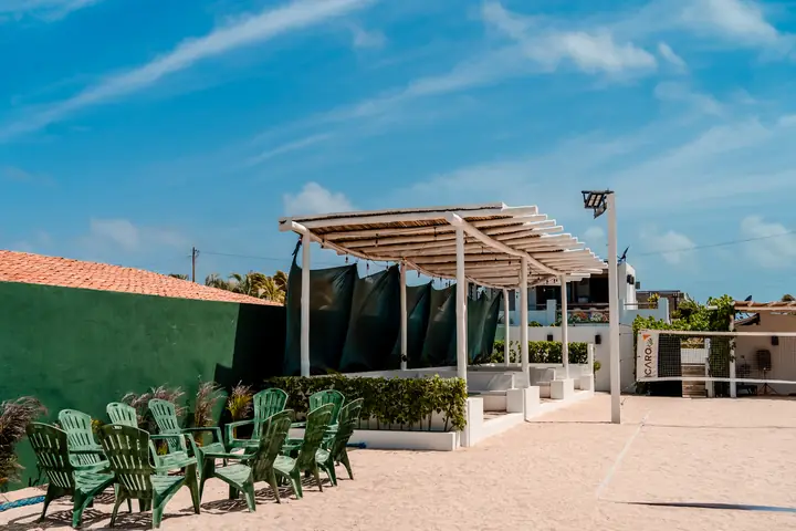 La cancha frente al mar con sillas de playa, lista para reunir gente.