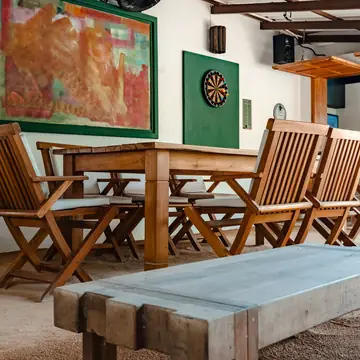 Mesa de madera y tablero de dardos en el área de juegos.