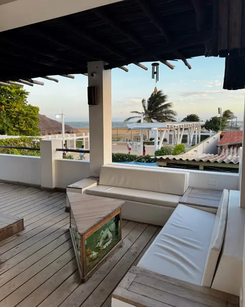 Sala de la terraza con sofás blancos y vista al mar.